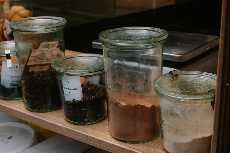 A variety of spices stored in glass jars lined on a shelf, perfect for kitchen organization